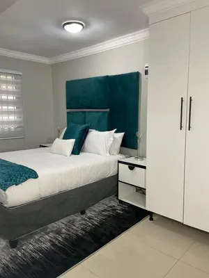 a bedroom with a large bed with a blue headboard at 36 On Blougom in Midrand