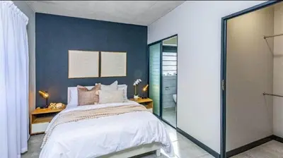 a bedroom with a large bed with a blue wall at Ndlovu Lifestyle Apartments in Midrand