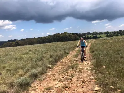 a person riding a bike on a dirt trail in a field at Greystone Lodge in Dullstroom