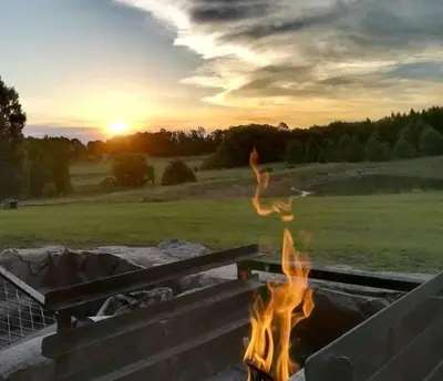 a fire pit with a person jumping over it at Greystone Lodge in Dullstroom