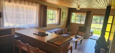 a living room with a table and a couch at Greystone Lodge in Dullstroom