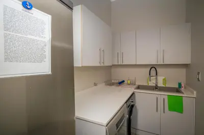 a kitchen with white cabinets and a sink and a window at Bunkers Paradis at Pecanwood in Hartbeespoort