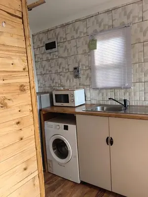 a kitchen with a washing machine and a microwave at Cabin in Pretoria West in Pretoria