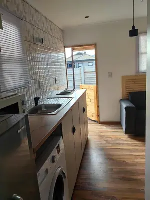 a kitchen with a sink and a washing machine at Cabin in Pretoria West in Pretoria