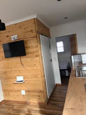 a room with a wooden wall with a flat screen tv at Cabin in Pretoria West in Pretoria