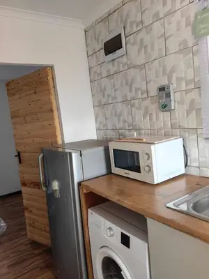 a kitchen with a microwave and a washing machine at Cabin in Pretoria West in Pretoria