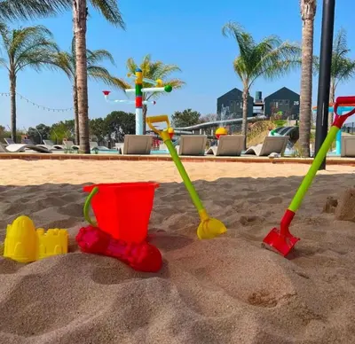 a group of toys in the sand on a beach at StayEase Modern Stay in Waterfall in Midrand