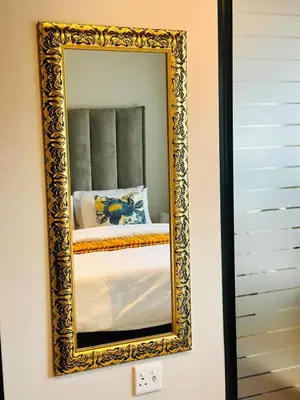 a mirror on a wall with a bed in it at StayEase Modern Stay in Waterfall in Midrand