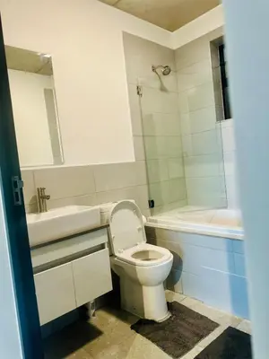 a bathroom with a toilet and a sink and a bath tub at StayEase Modern Stay in Waterfall in Midrand