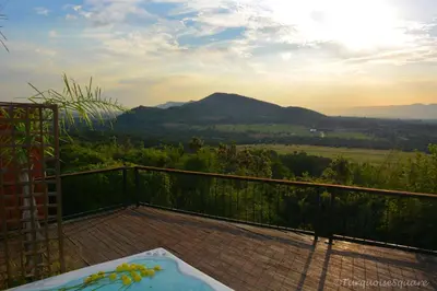 a hot tub on a balcony with mountains in the background at La Montagne Guest Lodge in Hartbeespoort