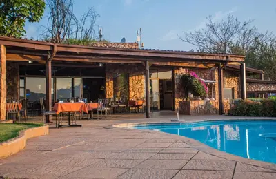 a patio with a table and a swimming pool at La Montagne Guest Lodge in Hartbeespoort