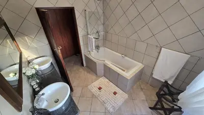 a bathroom with a sink and a bath tub at Bergendal Lodge in Hydro