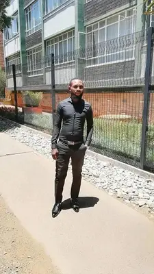 a man standing on a sidewalk in front of a building at Ramaderama in Pretoria
