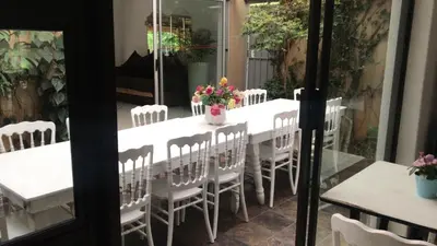 a white table with white chairs and flowers on it at Den Accommodation in Olifantsfontein