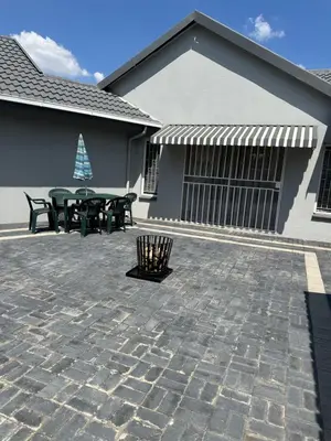 a patio with a picnic table and a building at Afrisky Guest House in Kempton Park