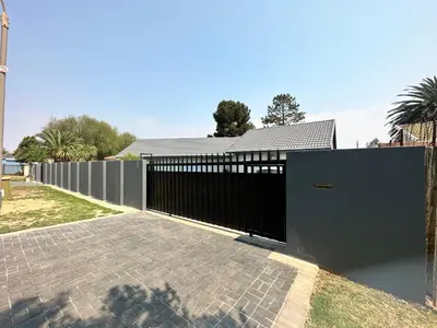 a black fence in front of a house at Afrisky Guest House in Kempton Park