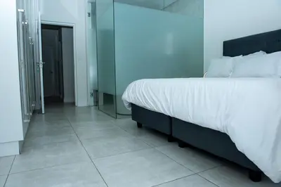 a bedroom with a large bed and a mirror at Fealathome Two Bedroom in Midrand
