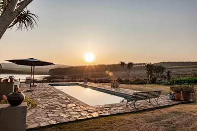 a swimming pool with a bench and an umbrella at 10onBrightside-Exp the epitome of country living in Nelspruit