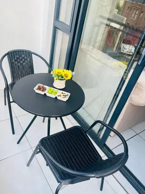 a black table and chair with a plate of food on it at Cozy Pretoria Apartment with City Garden Views in Pretoria