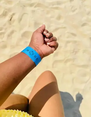 a person sitting on the beach with a blue wrist band at Cozy Pretoria Apartment with City Garden Views in Pretoria