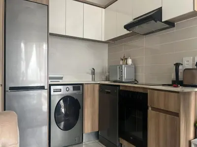 a kitchen with a dishwasher and a washer at Cozy Pretoria Apartment with City Garden Views in Pretoria