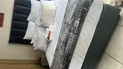 a bedroom with a bed with white pillows at Cozy Pretoria Apartment with City Garden Views in Pretoria