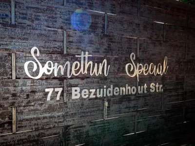 a sign on the side of a brick wall at Somethin Special Guest House 77A in Mokopane