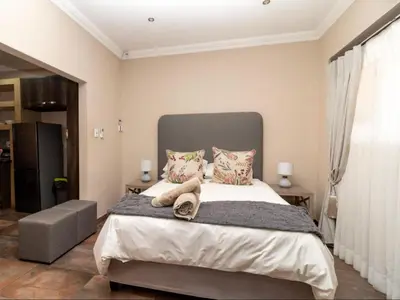 a bedroom with a large bed with two pillows at Somethin Special Guest House 77A in Mokopane