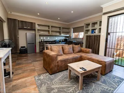 a living room with a brown couch and a table at Somethin Special Guest House 77A in Mokopane