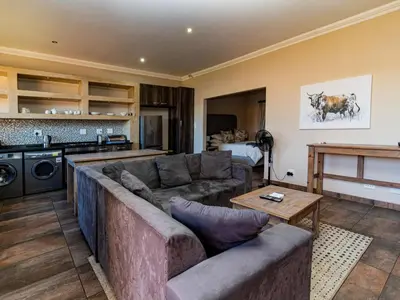 a living room with a couch and a kitchen at Somethin Special Guest House 77A in Mokopane