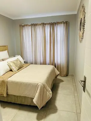 a bedroom with a large bed with a window at Homely Stay 4 in Kempton Park