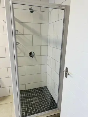 a shower with a glass door in a bathroom at Homely Stay 4 in Kempton Park
