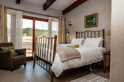 a bedroom with a bed and a chair and a window at Cottage, Eco Estate, private and tranquil in Gatehouse