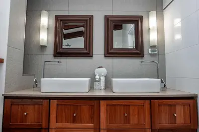 two sinks in a bathroom with two mirrors at Cottage, Eco Estate, private and tranquil in Gatehouse