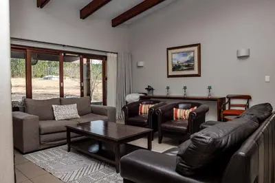 a living room with leather furniture and a table at Cottage, Eco Estate, private and tranquil in Gatehouse