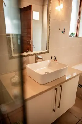 a bathroom with a white sink and a mirror at Cottage, Eco Estate, private and tranquil in Gatehouse