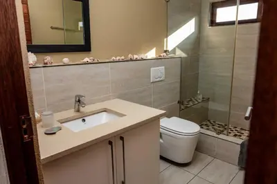a bathroom with a sink and a toilet and a shower at Cottage, Eco Estate, private and tranquil in Gatehouse