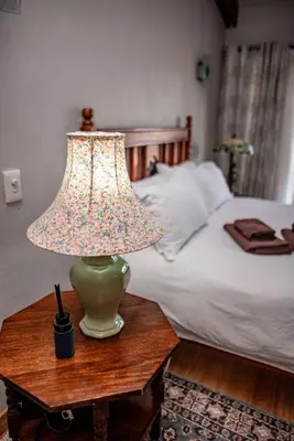 a lamp on a table next to a bed at Cottage, Eco Estate, private and tranquil in Gatehouse