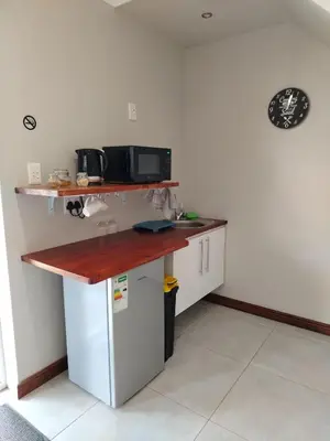 a kitchen with a counter with a microwave and a refrigerator at Grace 523 in Pretoria