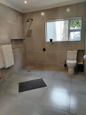a bathroom with a shower and a toilet and a window at Grace 523 in Pretoria