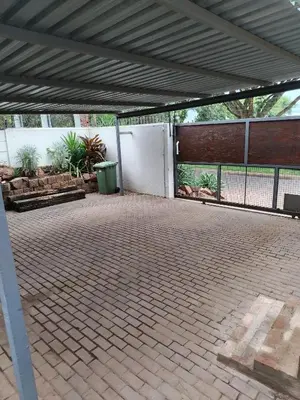 a covered patio with a fence and benches and a gate at Grace 523 in Pretoria