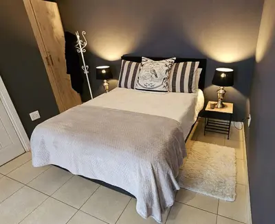 a bedroom with a large bed with two lamps at Belle Vie Boutique Guesthouse in Pretoria