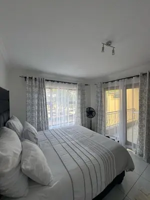 a bedroom with a large white bed with a window at Home away from Home in Midrand