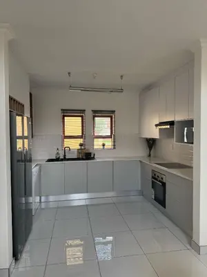a large kitchen with white cabinets and appliances at Home away from Home in Midrand