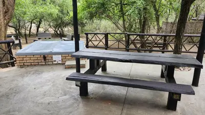a wooden bench sitting next to a picnic table at Parradys Marloth Park in Marloth Park
