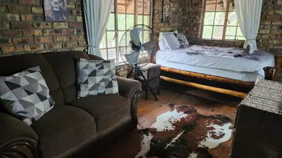 a living room with a couch and a bed at Parradys Marloth Park in Marloth Park