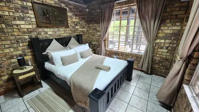 a bedroom with a bed in a brick wall at Parradys Marloth Park in Marloth Park