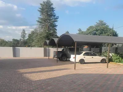 a parking lot with a car parked under a canopy at Ngwede Guest House in Lydenburg