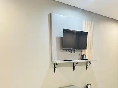 a flat screen tv on a shelf in a room at Ngwede Guest House in Lydenburg