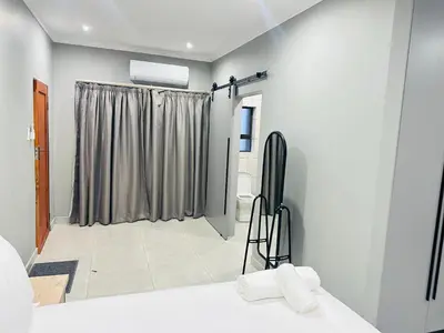 a bathroom with a room with a shower curtain at Ngwede Guest House in Lydenburg